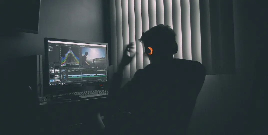 shallow focus photography of man listing to music in front of the computer